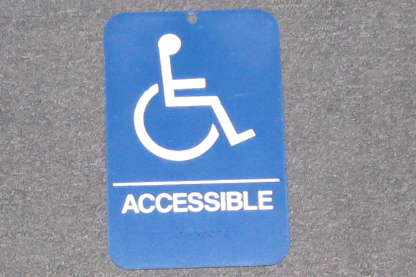 Sign-symbol of wheelchair with ACCESSIBLE + braille lettering, stock number S-1238