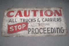 Sign-Caution all trucks and carriers stop before proceeding, period, stock number S-0301
