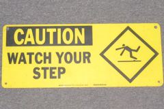 Sign-Caution Watch Your Step, w/ picture of man tripping, plastic, stock number S-0836