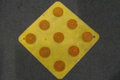 Sign-9 orange reflectors(3" diam) on yellow metal placard, 24"w x, stock number S-0900