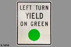 Sign-Left Turn Yield On Green, w/ green circle, white & black, metal, stock number S-1010